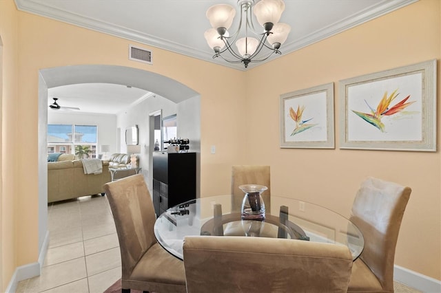 tiled dining area featuring ceiling fan with notable chandelier and crown molding