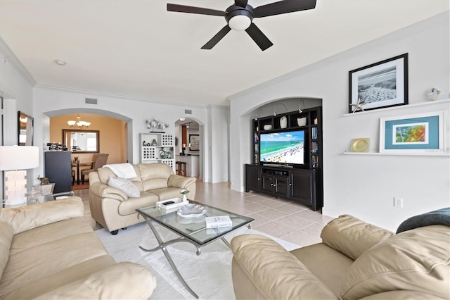 living room featuring light tile patterned flooring, crown molding, and ceiling fan with notable chandelier