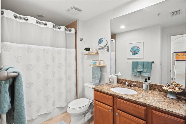 bathroom with tile patterned flooring, toilet, and vanity