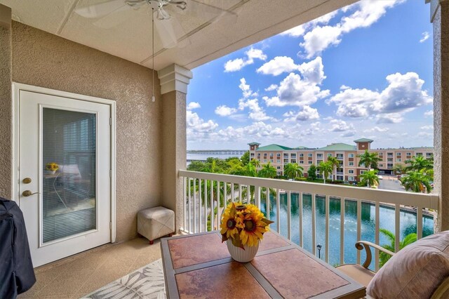 balcony with a water view and ceiling fan