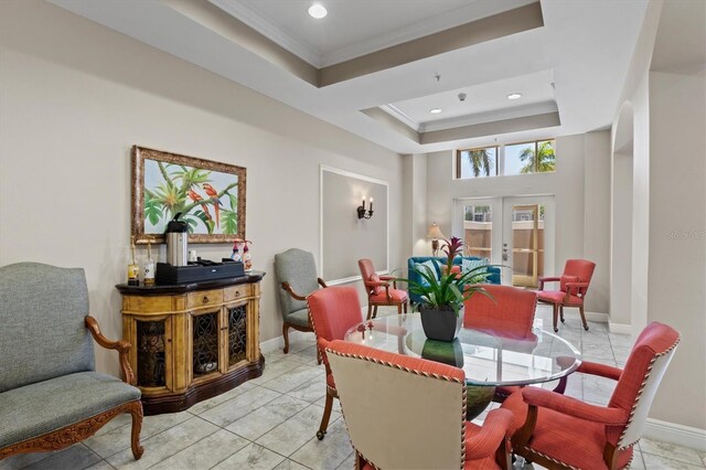 dining space with ornamental molding, light tile patterned floors, french doors, and a raised ceiling