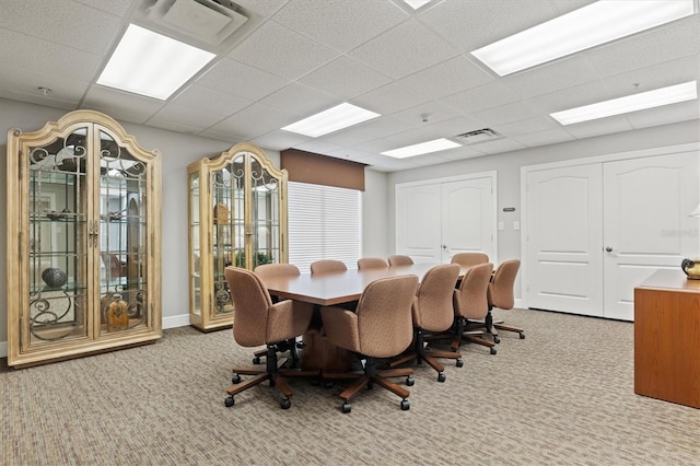 dining space with light colored carpet and a paneled ceiling