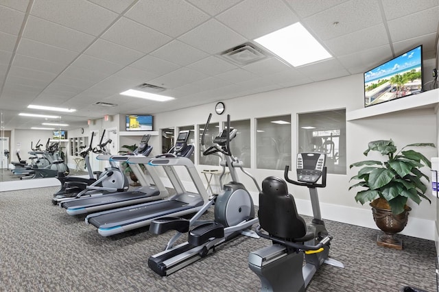 exercise room featuring a paneled ceiling and carpet