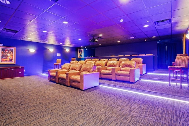 cinema room with carpet flooring and a drop ceiling