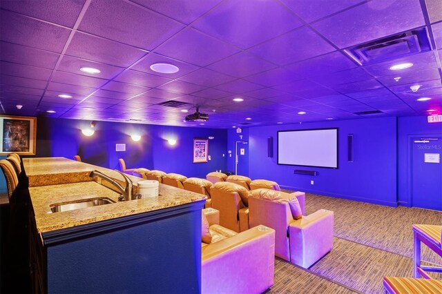 home theater with light carpet, sink, and a paneled ceiling