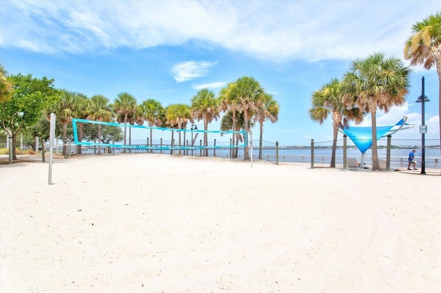 view of community with a water view, a beach view, and volleyball court