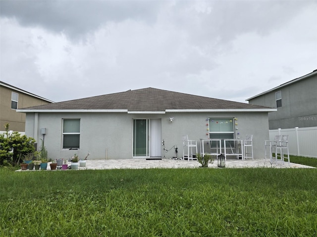 rear view of property featuring a patio area and a lawn