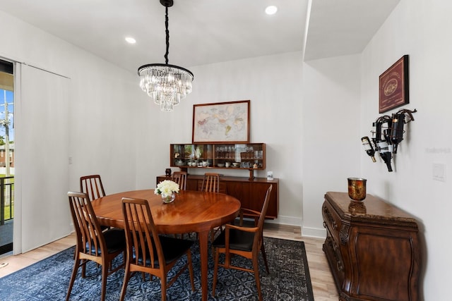 dining room with baseboards, light wood-type flooring, an inviting chandelier, and recessed lighting