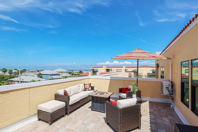 view of patio / terrace with a residential view, an outdoor living space with a fire pit, and a balcony