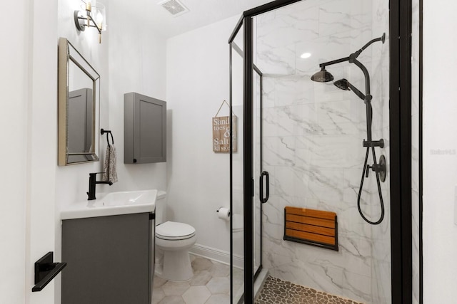 full bathroom with a marble finish shower, visible vents, toilet, vanity, and baseboards