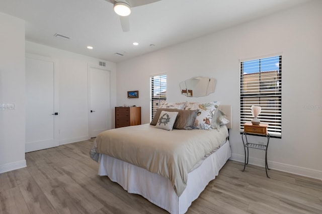 bedroom with multiple windows, light wood-type flooring, and visible vents