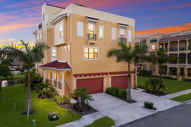 view of front facade featuring an attached garage, a front lawn, and stucco siding