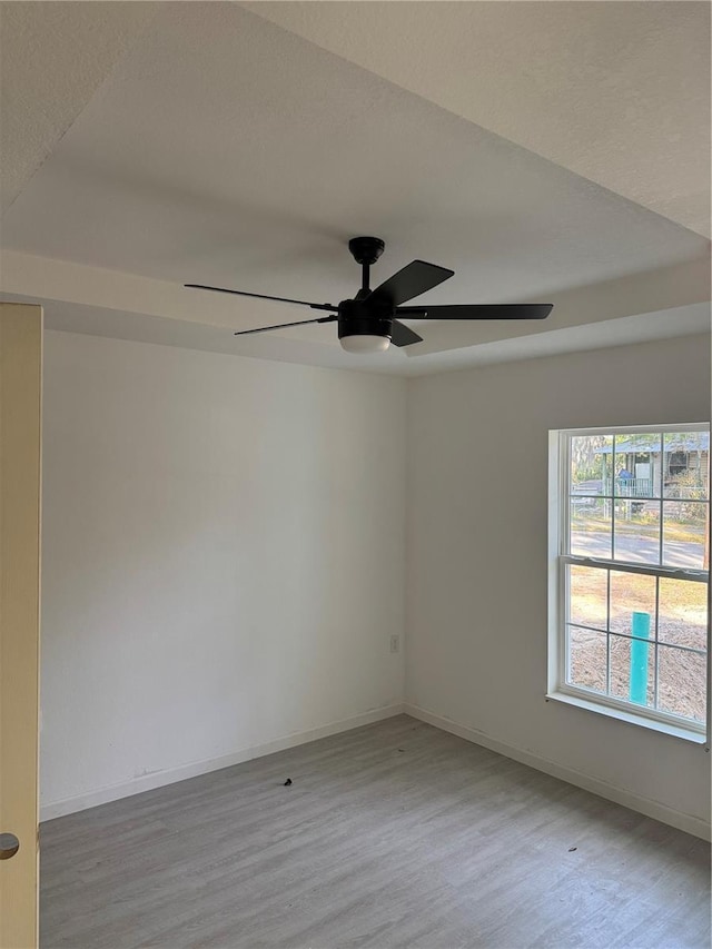 spare room with light wood-type flooring and ceiling fan