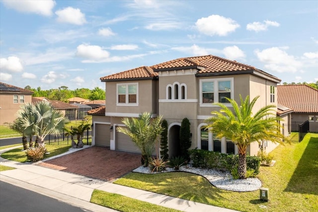 mediterranean / spanish-style home featuring a garage and a front yard