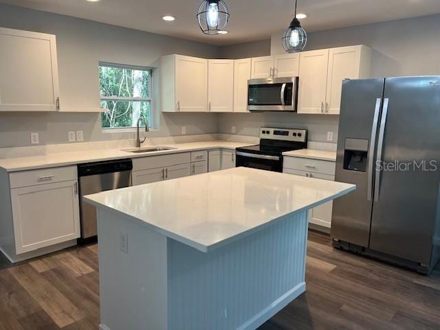 kitchen with white cabinets, appliances with stainless steel finishes, hanging light fixtures, and sink