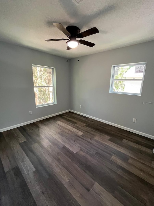 empty room featuring a textured ceiling, ceiling fan, and dark hardwood / wood-style floors