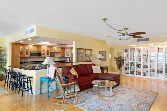 living room featuring light hardwood / wood-style flooring and ceiling fan