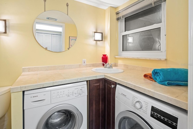 clothes washing area with sink and washer and clothes dryer