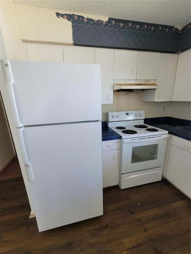 707 13th St W, Palmetto, FL 34221 - kitchen featuring white appliances, white cabinets, dark countertops, and under cabinet range hood