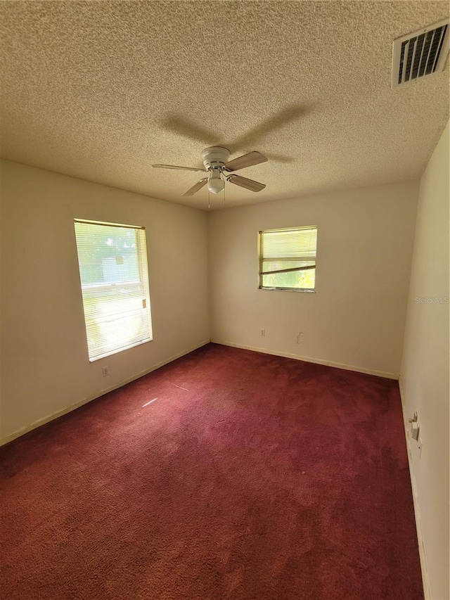 707 13th St W, Palmetto, FL 34221 - unfurnished room with visible vents, a textured ceiling, dark colored carpet, baseboards, and ceiling fan