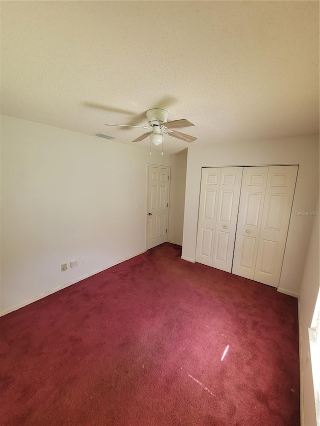 707 13th St W, Palmetto, FL 34221 - unfurnished bedroom with visible vents, carpet floors, a closet, a textured ceiling, and a ceiling fan