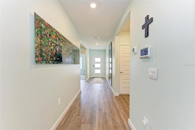 corridor with hardwood / wood-style floors