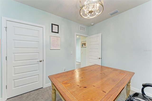 home office with carpet and an inviting chandelier