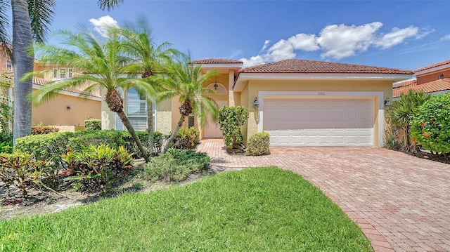 mediterranean / spanish-style home with a garage and a front yard