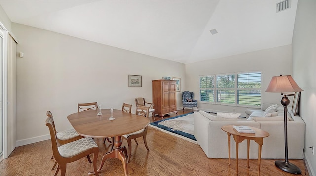 dining room featuring light hardwood / wood-style floors and high vaulted ceiling