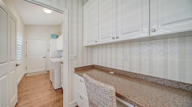 clothes washing area with cabinets, light hardwood / wood-style flooring, and washing machine and dryer