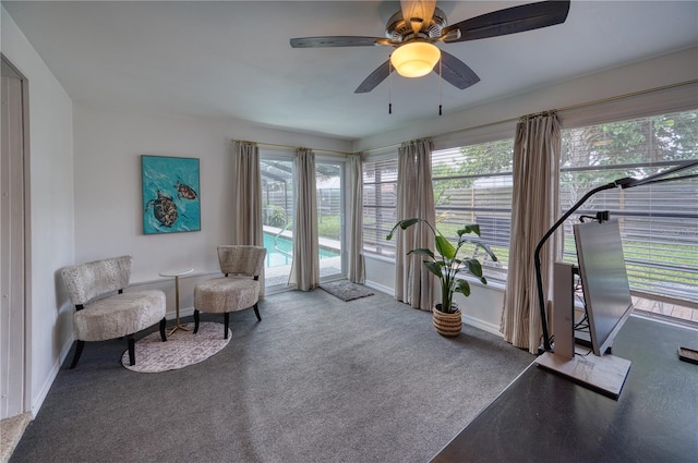 living area featuring carpet floors and ceiling fan