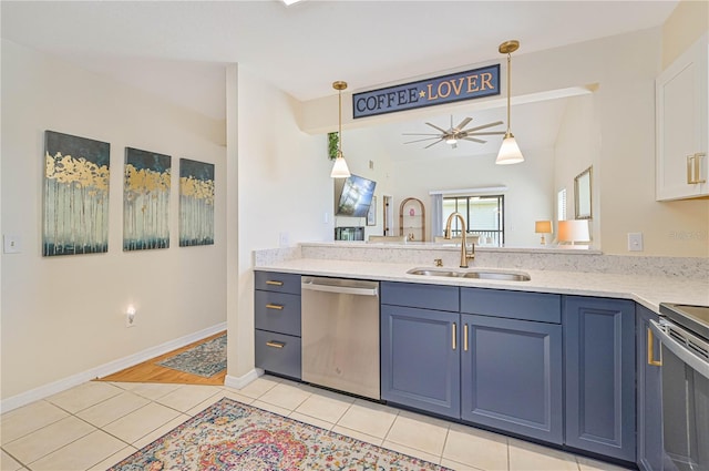 kitchen with blue cabinets, sink, light tile patterned floors, and appliances with stainless steel finishes