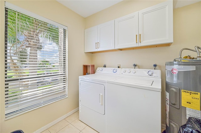 laundry area with cabinets, washer and dryer, light tile patterned floors, a wealth of natural light, and water heater