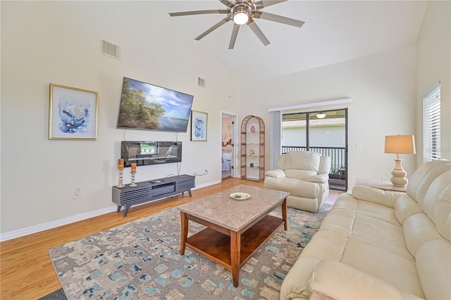 living room with ceiling fan, plenty of natural light, high vaulted ceiling, and wood-type flooring