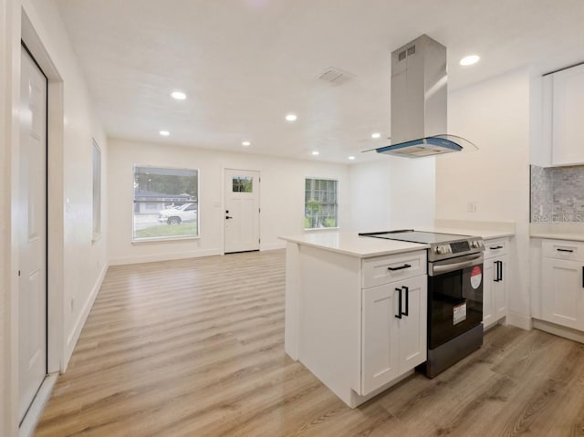 kitchen featuring electric stove, light hardwood / wood-style flooring, white cabinets, and island exhaust hood