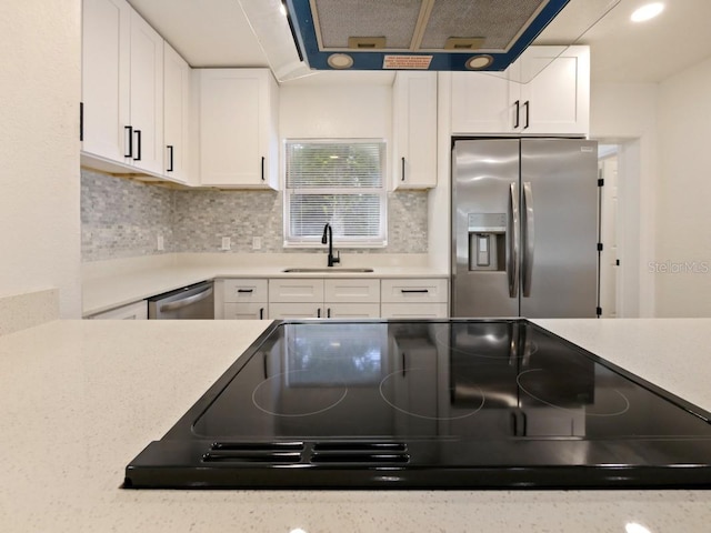 kitchen with white cabinetry, stainless steel appliances, sink, and tasteful backsplash