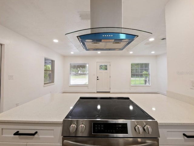 kitchen with light stone counters, stainless steel range with electric stovetop, and white cabinets