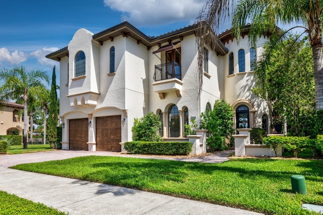 mediterranean / spanish-style home with a balcony, a garage, and a front yard