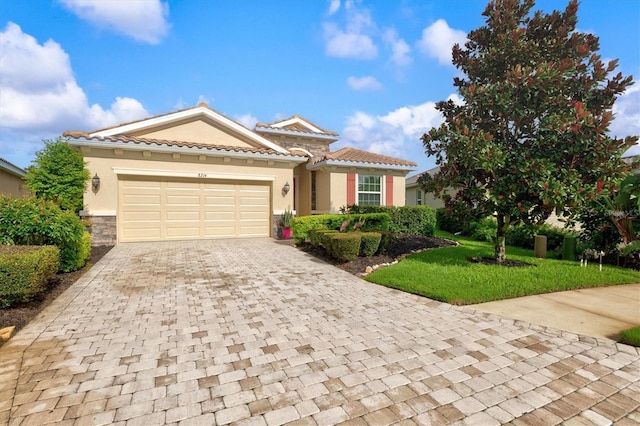 view of front of home featuring a garage, a tiled roof, decorative driveway, and stucco siding