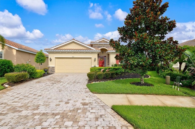 view of front of home featuring decorative driveway, stucco siding, a garage, a tiled roof, and a front lawn