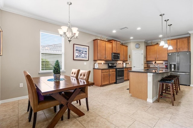 kitchen with brown cabinets, a center island with sink, stainless steel appliances, dark countertops, and hanging light fixtures