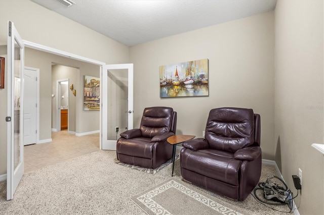 sitting room featuring light tile patterned flooring, baseboards, and french doors