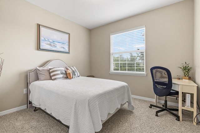 bedroom with light carpet and baseboards