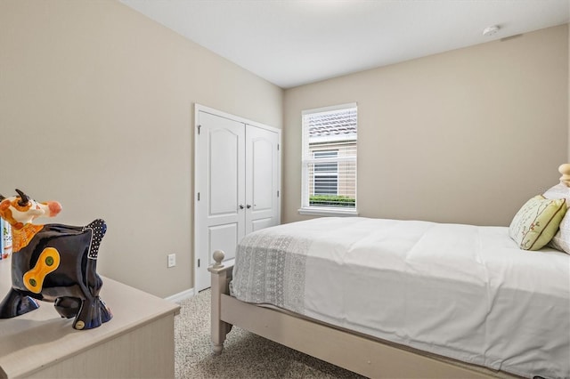 bedroom with light carpet, baseboards, and a closet