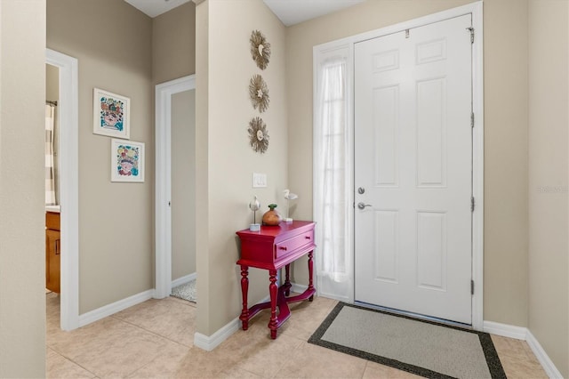 entrance foyer with light tile patterned floors and baseboards