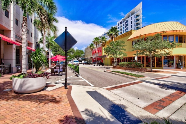 view of road with sidewalks, street lighting, and curbs