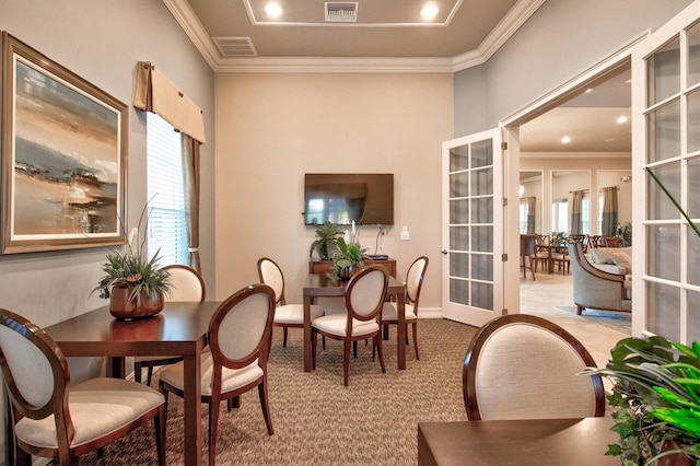 dining space featuring ornamental molding, french doors, visible vents, and light colored carpet