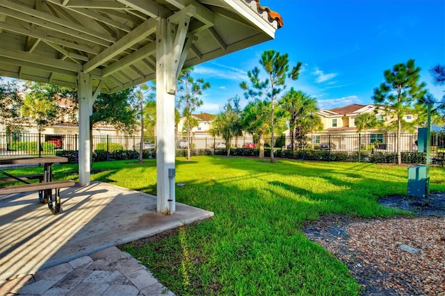 view of yard featuring a residential view, fence, and a patio