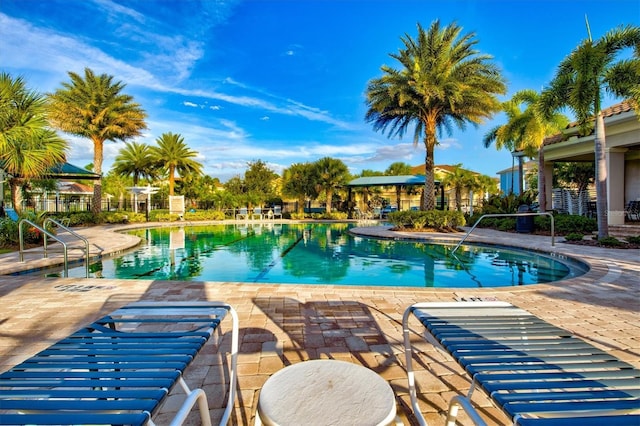 pool with a patio and fence