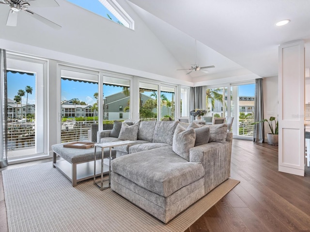 living room with plenty of natural light, dark wood-type flooring, lofted ceiling, and ceiling fan